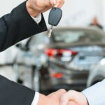 wo men shaking hands giving one the keys to a new leased company car