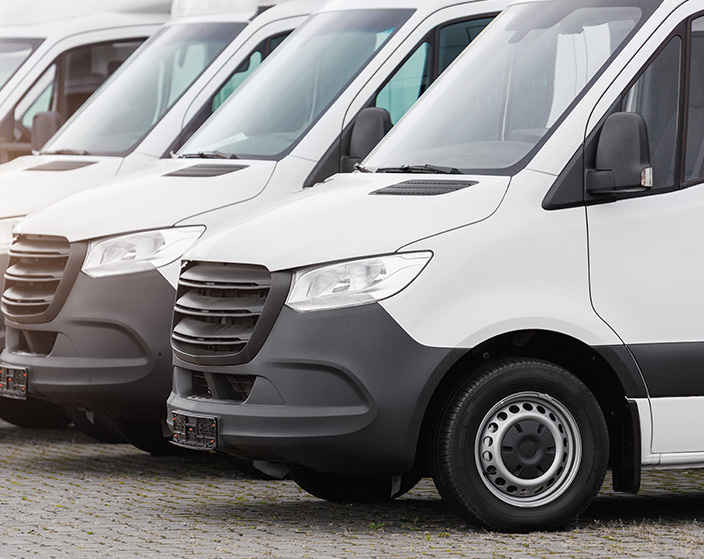 Fleet of white cargo sprinter vans prepared for inspection and maintenance